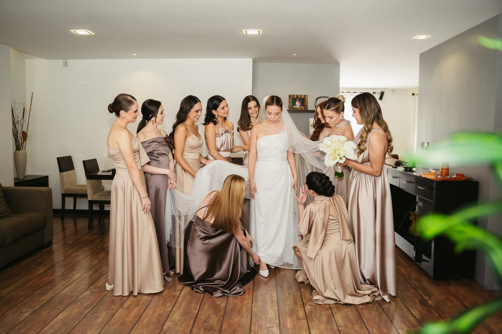 Damas de honor ayudando a la novia con el vestido antes de la ceremonia