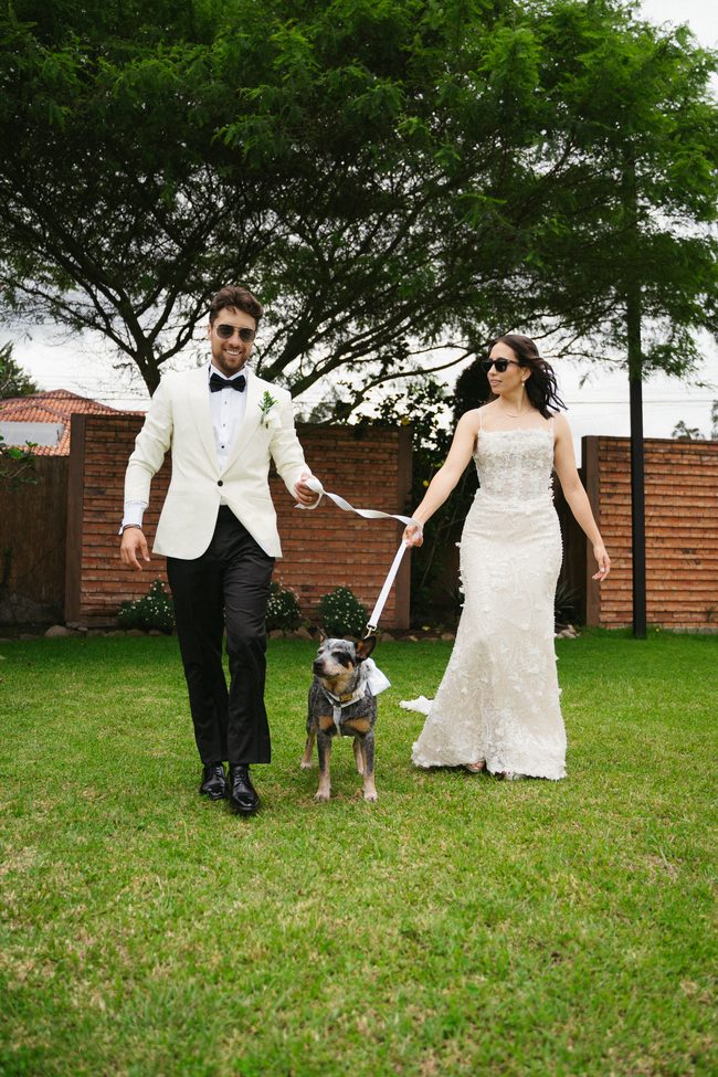 Los novios caminando con su perro después de la ceremonia