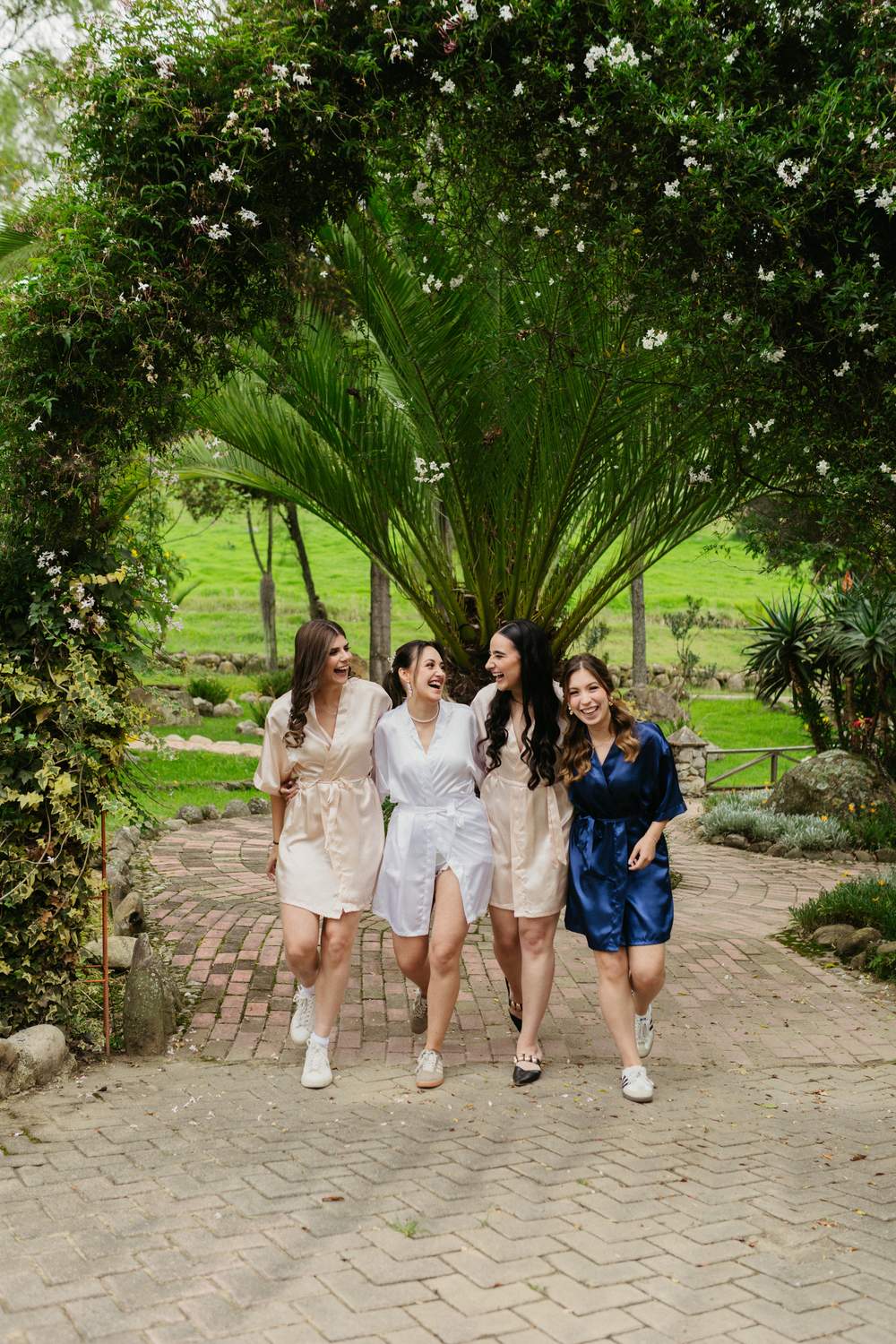 Damas de honor caminando bajo un arco de jardín